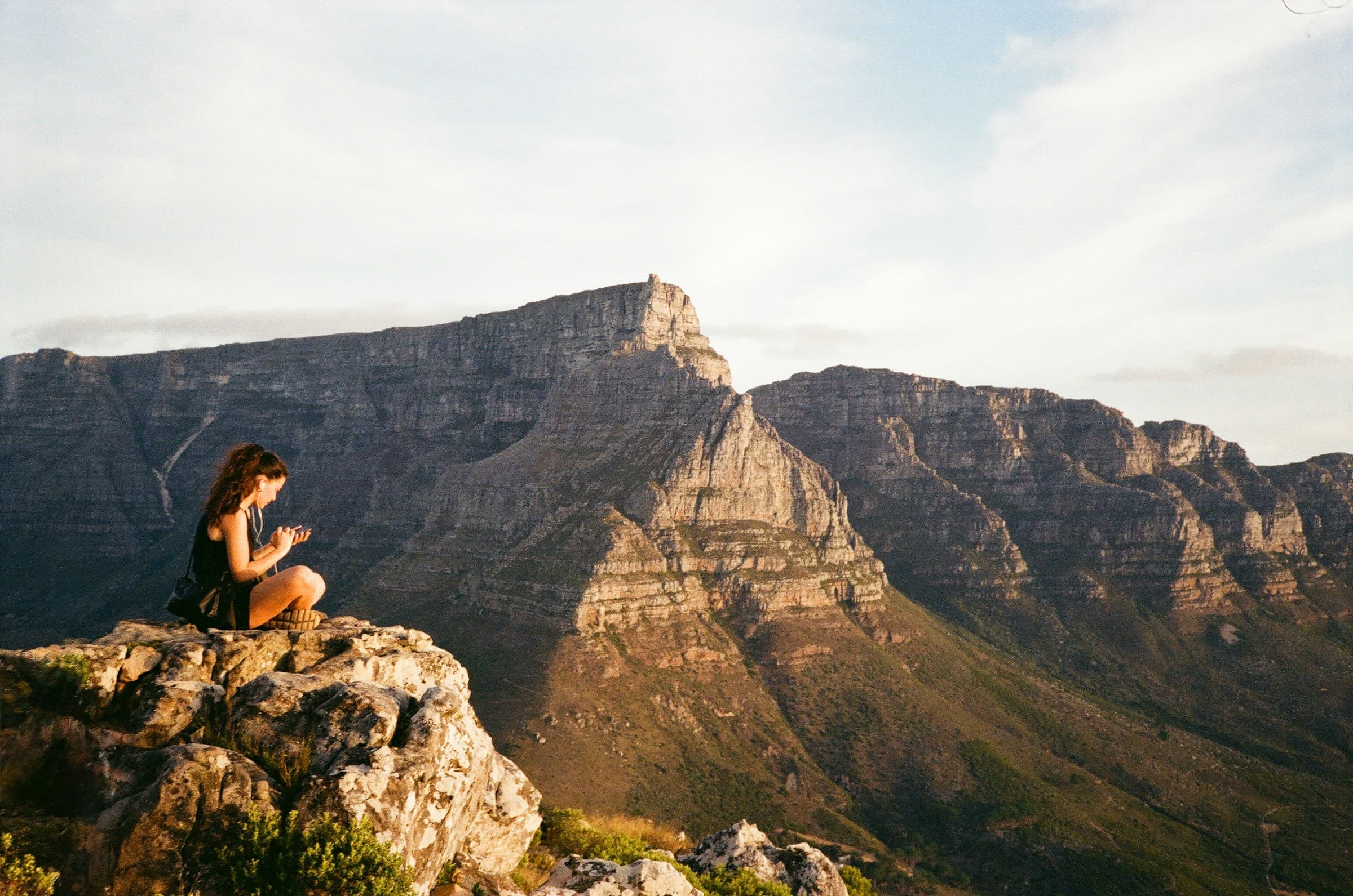 Woman wearing headphones overlooking a mountain landscape